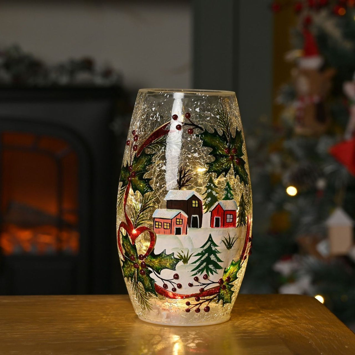 The Crackle Glass Christmas LED Vase with Winter Cottage and Leaf Scene creates a charming centrepiece for seasonal interiors.