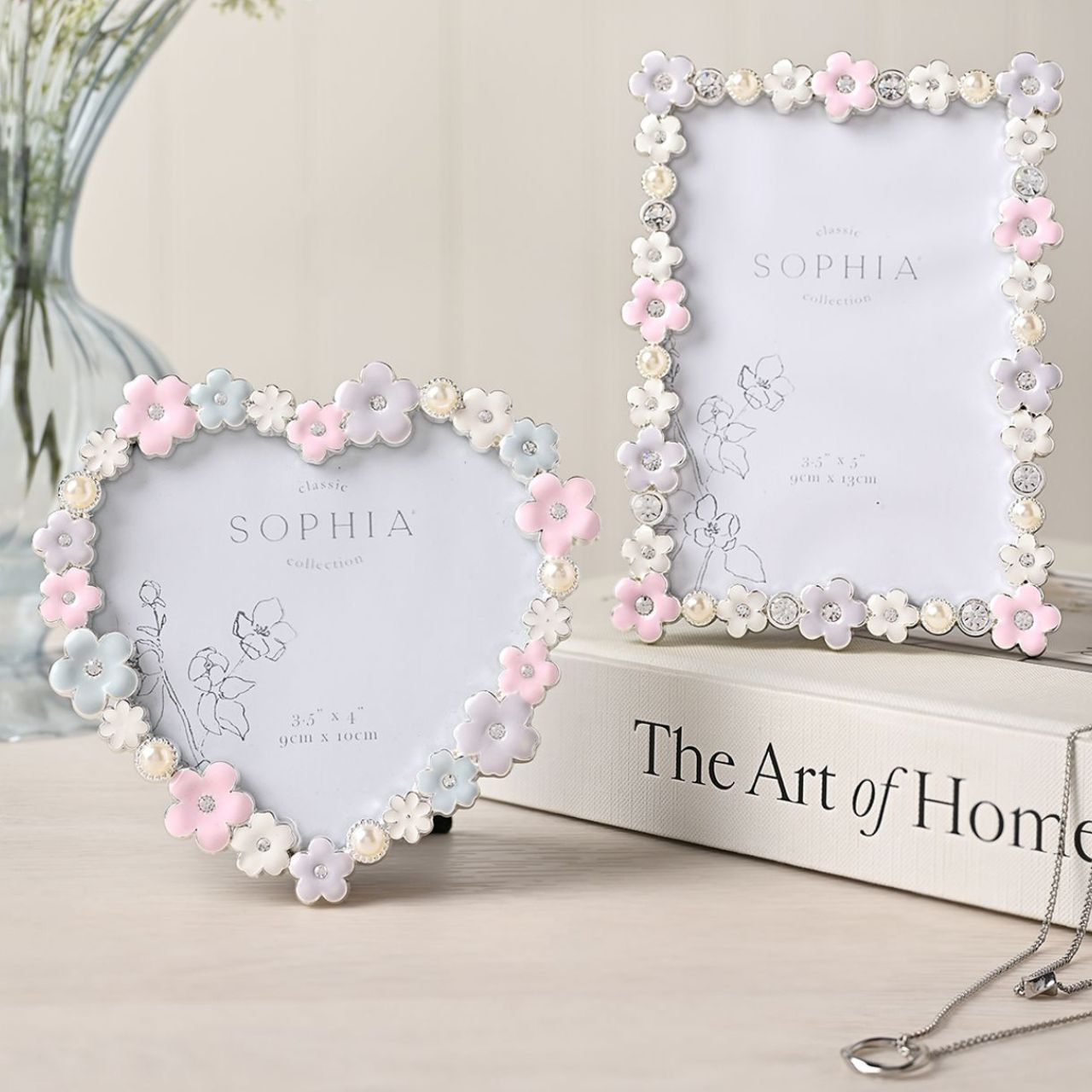 Make your memories bloom with the Sophia Classic Daisy 4 x 6 Heart Frame in Pastel. This heart-shaped frame, adorned with delicate white and pink flowers, offers a charming home for your cherished photos, adding pastel charm to any decor.