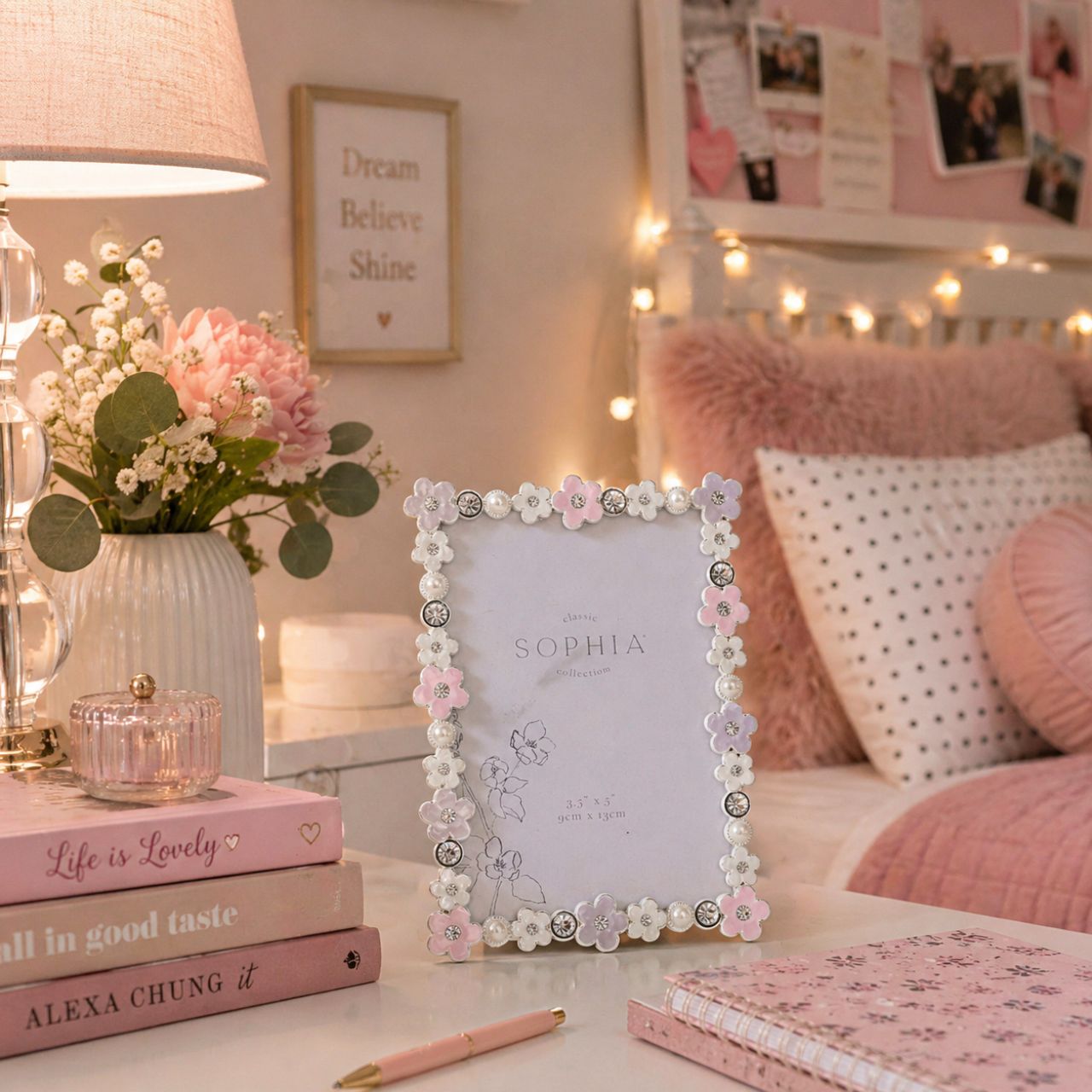 Introducing the Sophia Classic Daisy 3.5" x 5" Frame - Pastel, a delightfully charming piece that pairs perfectly with precious memories. Adorned with delicate white and pink flowers, it’s a treat for the eyes, while sparkling rhinestones add glamour.