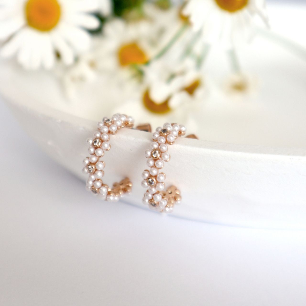 Elevate your elegance with the Tipperary Daisy Pink Pearl Hoop Cluster Gold Earrings. Featuring delicately clustered pink pearls on a refined gold hoop, these earrings offer a subtle yet striking statement.