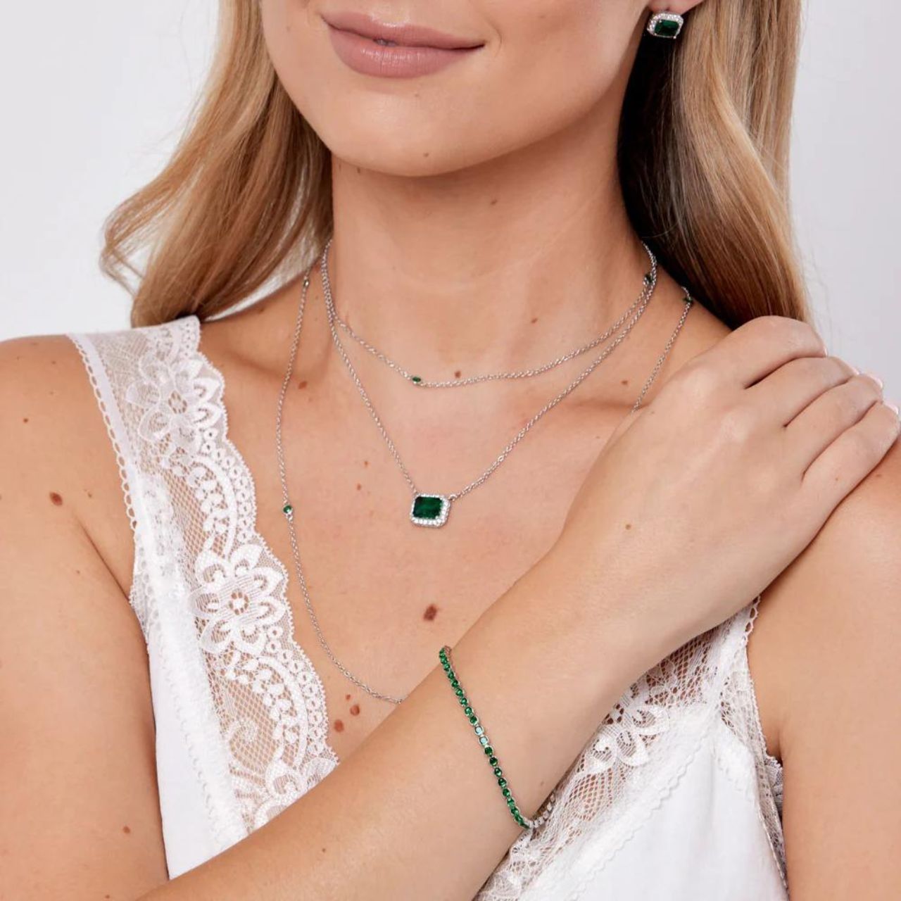 Dakota Emerald Tennis Bracelet by Knight & Day  Miniature rhodium plated tennis bracelet with Emerald CZ stones. Elegant when worn alone and also ideal for layering with watch or other bracelets. Fold over clip fastening.