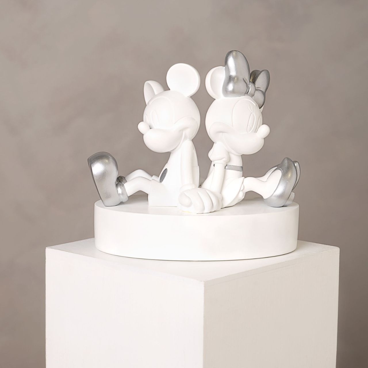 This substantial money box features the iconic pair holding hands back-to-back. This resin sculpture is a contemporary styled, statement figurine. The money slot is located at the back, with an easy-to-remove rubber plug on its base for retrieval of funds.