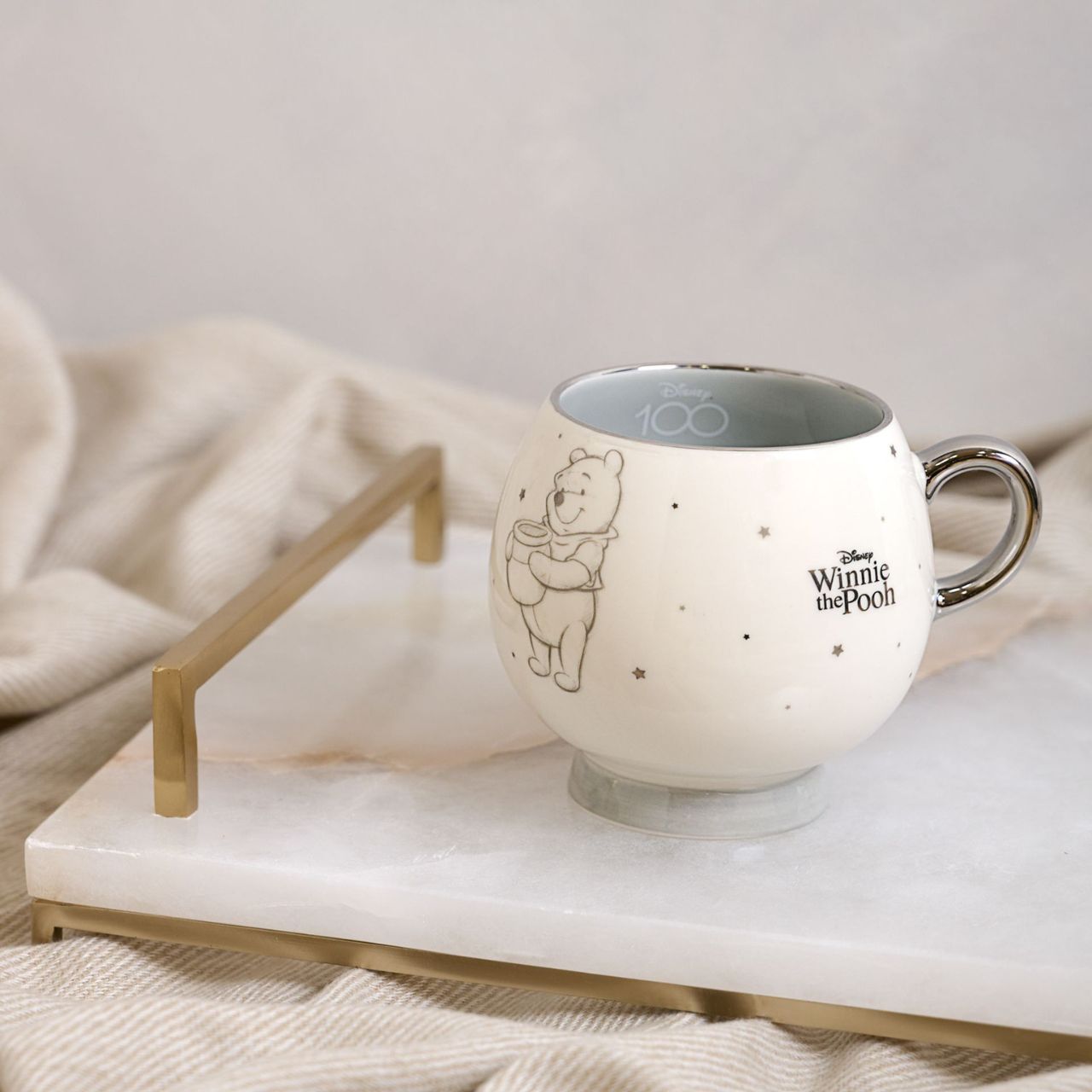Disney 100th Anniversary Premium Mug - Winnie  A Winnie premium mug from Disney 100 by DISNEY.  This limited edition mug captures the true magic of Disney on its centenary and can be enjoyed by fans of all ages.