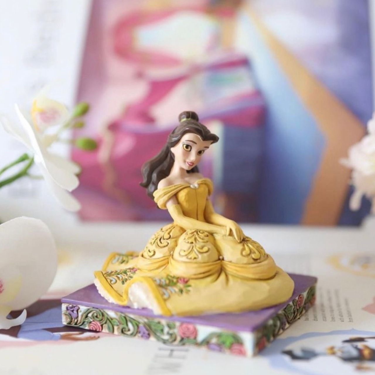 Disney Beauty and the Beast Be Kind Belle Figurine by Jim Shore  Dressed for the ball in a golden gown decorated in exquisite detail, the striking personality pose from artist Jim Shore depicts the radiant beauty of Belle from the Disney classic Beauty and the Beast.
