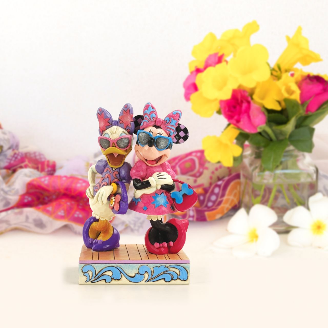 Disney "Fashionable Friends" Minnie and Daisy Figurine by Jim Shore  "Fashionable Friends" Mickey Mouse and Donald Duck would be nothing without their better and more fashionable halves! Minnie and Daisy don their finest duds to hit the town in style. Wearing shades, bows, matching purses and high heels, these ladies strike a power pose.