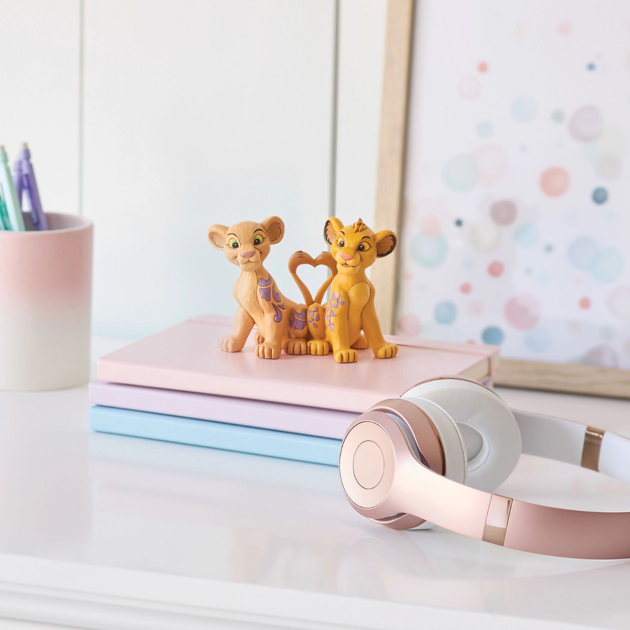 Celebrate the circle of love with Simba and Nala from Disney's Lion King, with this charming Jim Shore design featuring the young pair. Their tails form a heart as they sit close, adorned with Jim Shore's signature rosemaling and floral flourishes.
