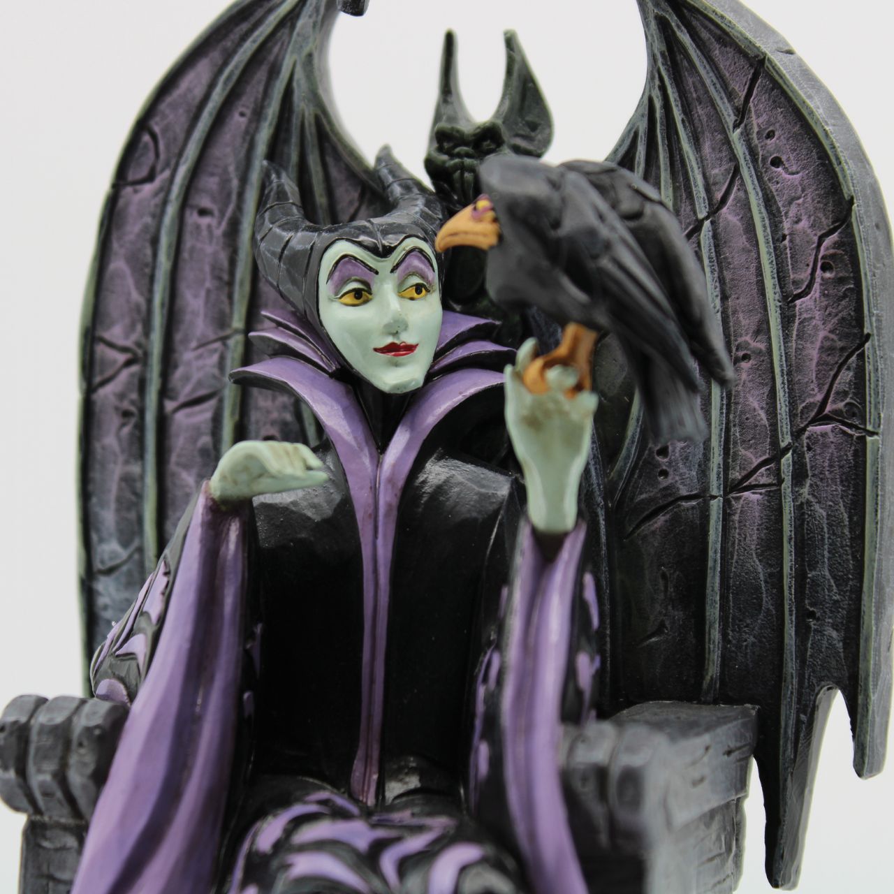 Maleficent sits atop her throne with her raven, Diavel. Dressed in her signature black with horned headdress, she is every piece the iconic villain from Sleeping Beauty. Designed by Jim Shore for his Disney Traditions collection.