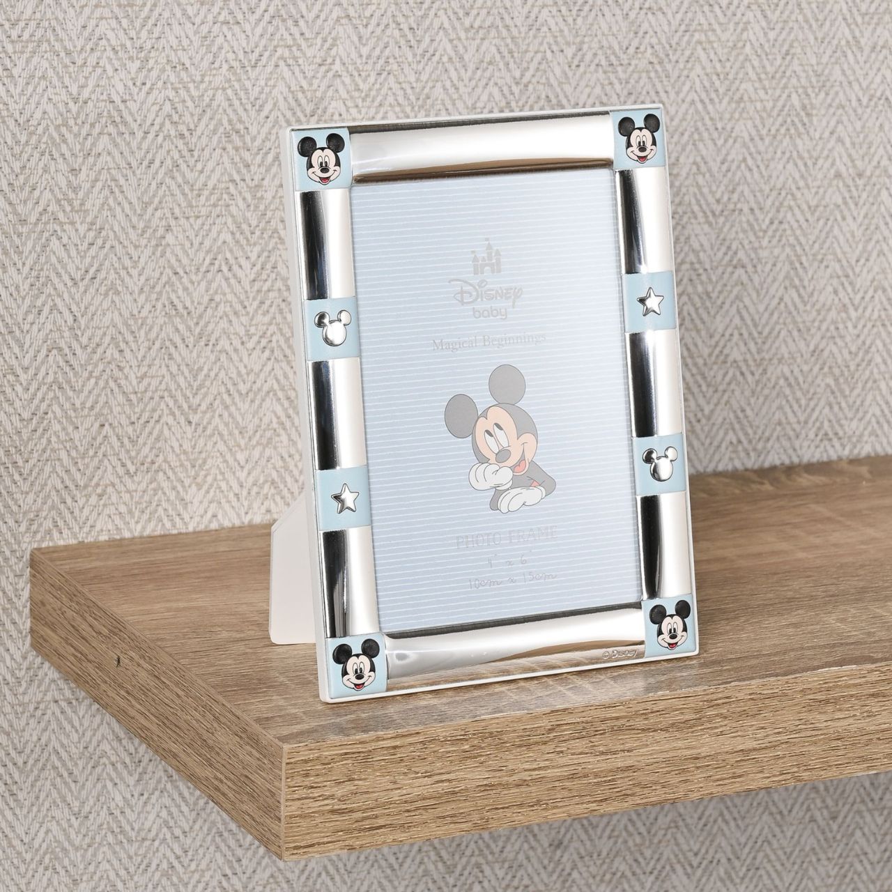 Bring Disney magic home with this charming Mickey Mouse photo frame, perfect for cherished memories. Adorned with Mickey's iconic ears and stars, this silver-plated frame is a must-have for any Disney fan.