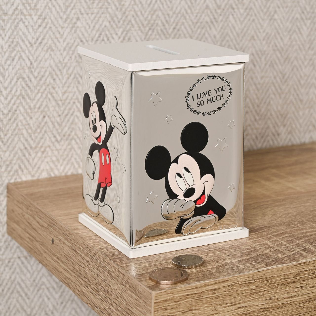 Bring the magic of Disney into your home with this delightful Mickey Mouse money bank. Crafted from white wood and adorned with real 999 silver plating, this charming box features playful illustrations of the beloved character in classic black and red.