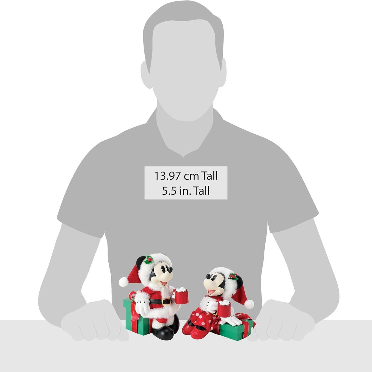 Capture the magic of the season with this charming Department 56 Disney figurine. Mickey and Minnie Mouse are nestled together on festive wrapped gifts, each cradling a steaming mug of hot cocoa—the perfect scene of cosy holiday togetherness.