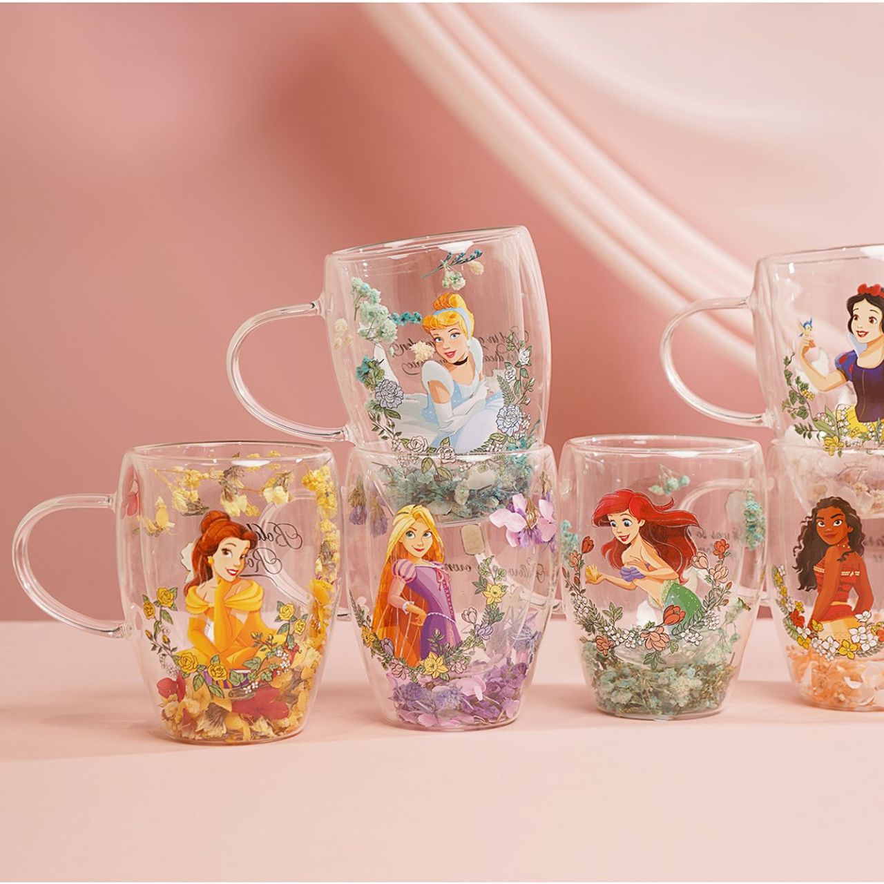 Step into the enchanting world of Disney with the Pastel Princess Glass Mug, adorned with a colourful illustration of Cinderella amidst a cascade of dried flowers.