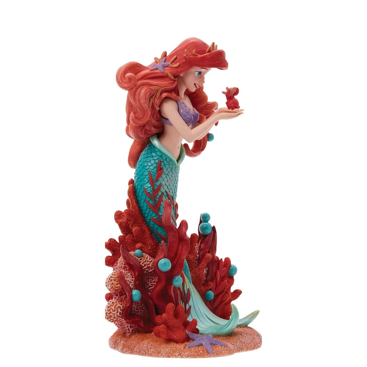 Ariel joins the Disney Showcase Botanical collection in honour of the film's 35th Anniversary featuring sea florals and coral (which is the 35th Anniversary gift). Ariel holds a small Sabastian in her delicate hands as she listens intently to his story. A vibrant base of coral, sand and rising bubbles encapsulates the underwater princess.