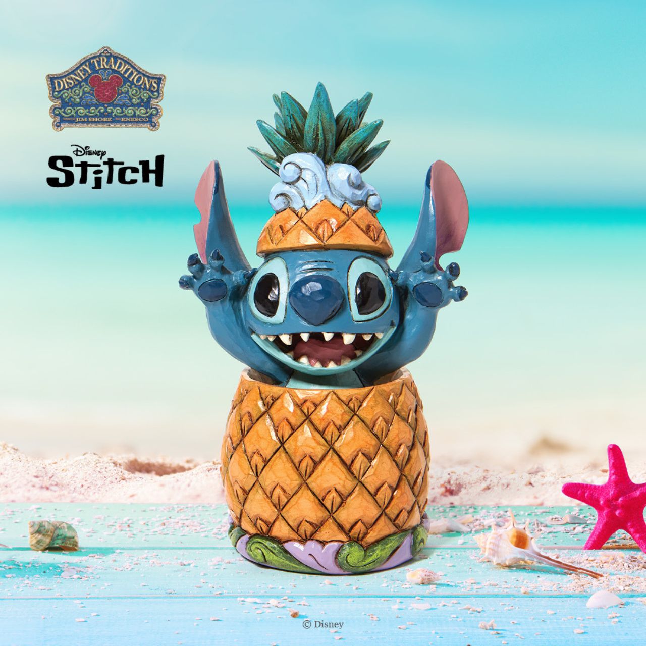 Disney Traditions Stitch in a Pineapple Figurine by Jim Shore  "Pineapple Pal" Popping cheerfully out a pineapple, Stitch celebrates the day and the twenty year anniversary of the film that brought him into our hearts. Wearing the pineapple top as a hat, the cheerful alien reaches for a hug.