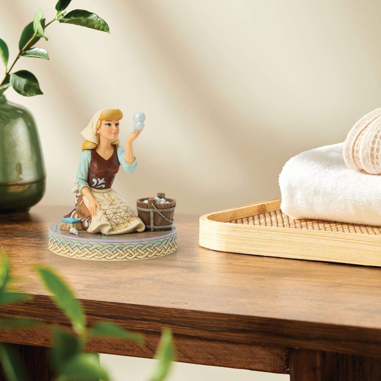 Cinderella's spirit remains unbroken in this inspiring Jim Shore scene. Dressed as a maid, she finds joy in her work, catching a bubble as she scrubs the floors. Jim Shore's enchanting details capture her beauty and resilience.