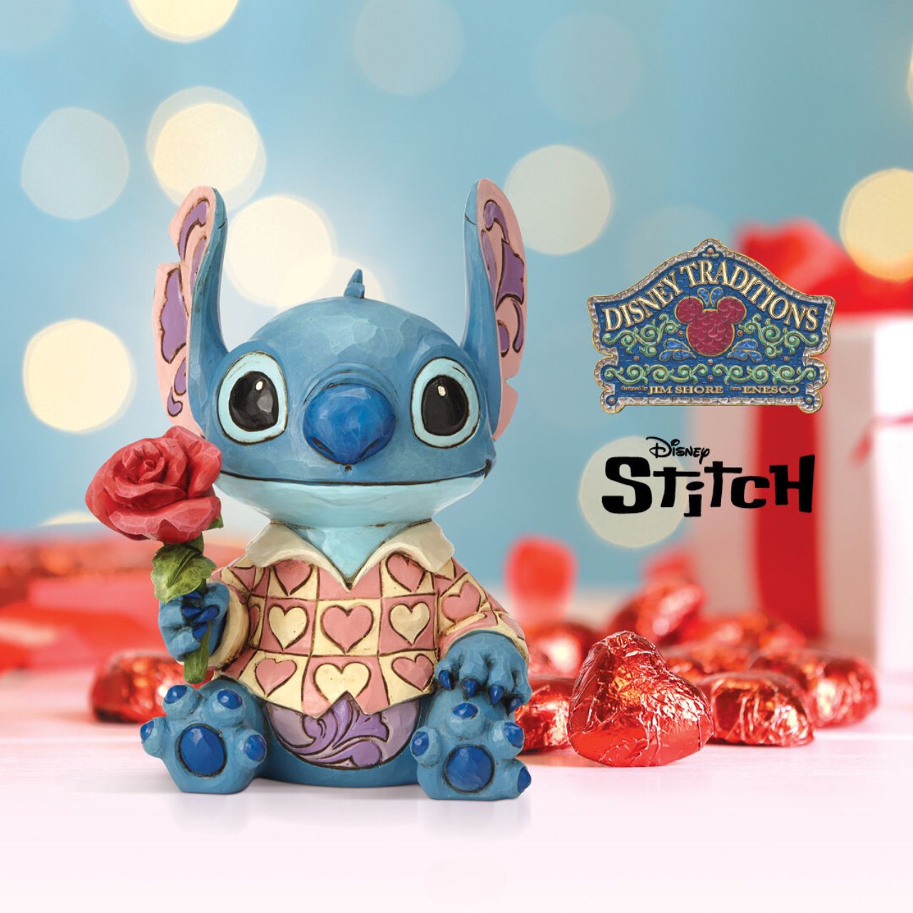 Disney Traditions Clueless Casanova Stitch Figurine  Stitch has transformed into a model citizen that Lilo would be proud of! Designed by Jim Shore, the adorable alien wears a heart-patterned shirt as he offers a single red rose. Stitch makes a great gift for your Ohana.
