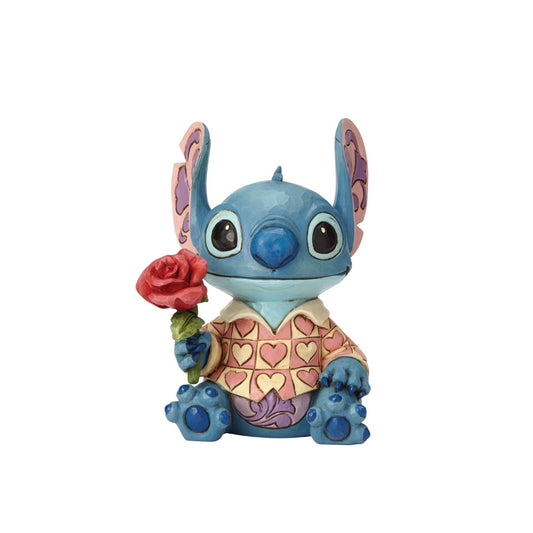 Stitch has transformed into a model citizen that Lilo would be proud of! Designed by Jim Shore, the adorable alien wears a heart-patterned shirt as he offers a single red rose. Stitch makes a great gift for your Ohana.