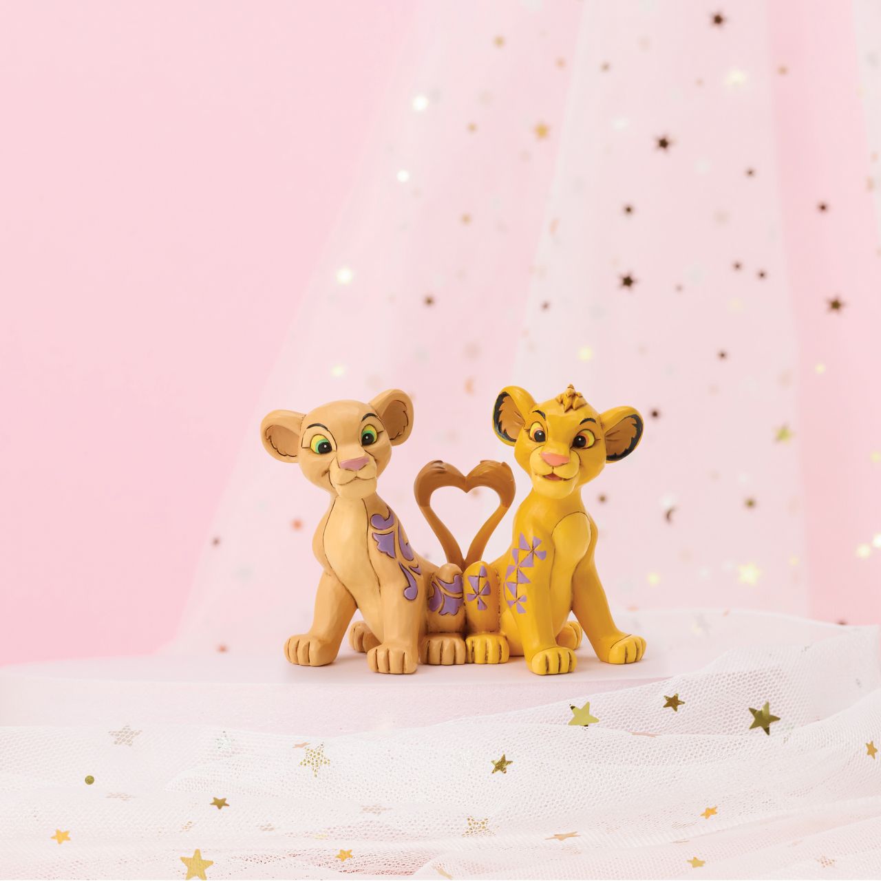Celebrate the circle of love with Simba and Nala from Disney's Lion King, with this charming Jim Shore design featuring the young pair. Their tails form a heart as they sit close, adorned with Jim Shore's signature rosemaling and floral flourishes.