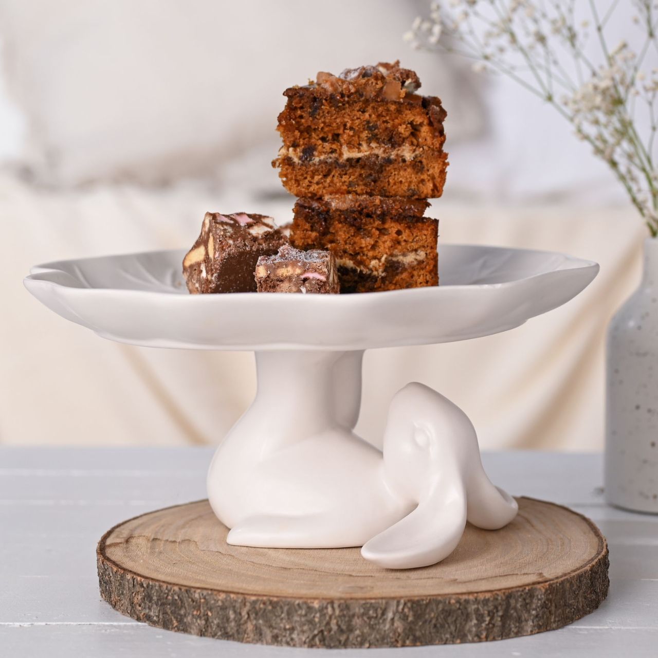This delightful bunny cake stand features a playful design, perfect for displaying cakes and pastries.