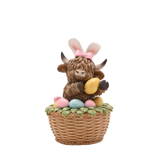 A seasonal update on a popular design, The Eggs-traordinary Gifting Co. Highland Cow in an Easter Basket figurine features the character with bunny ears.