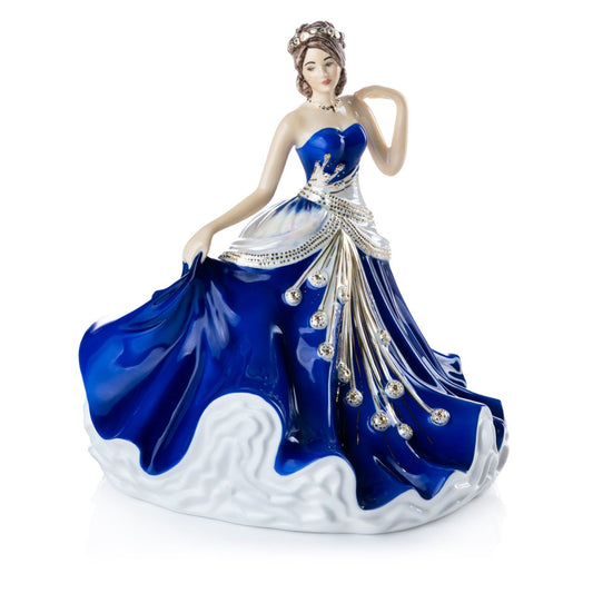 English Ladies Going to the Ball Midnight  Going to the Ball midnight is a beautifully hand-made figurine decorated in a deep royal blue colourway. This sophisticated piece is detailed with mother-of-pearl lustre and real 24-carat gold highlights that glisten when hit by the light.