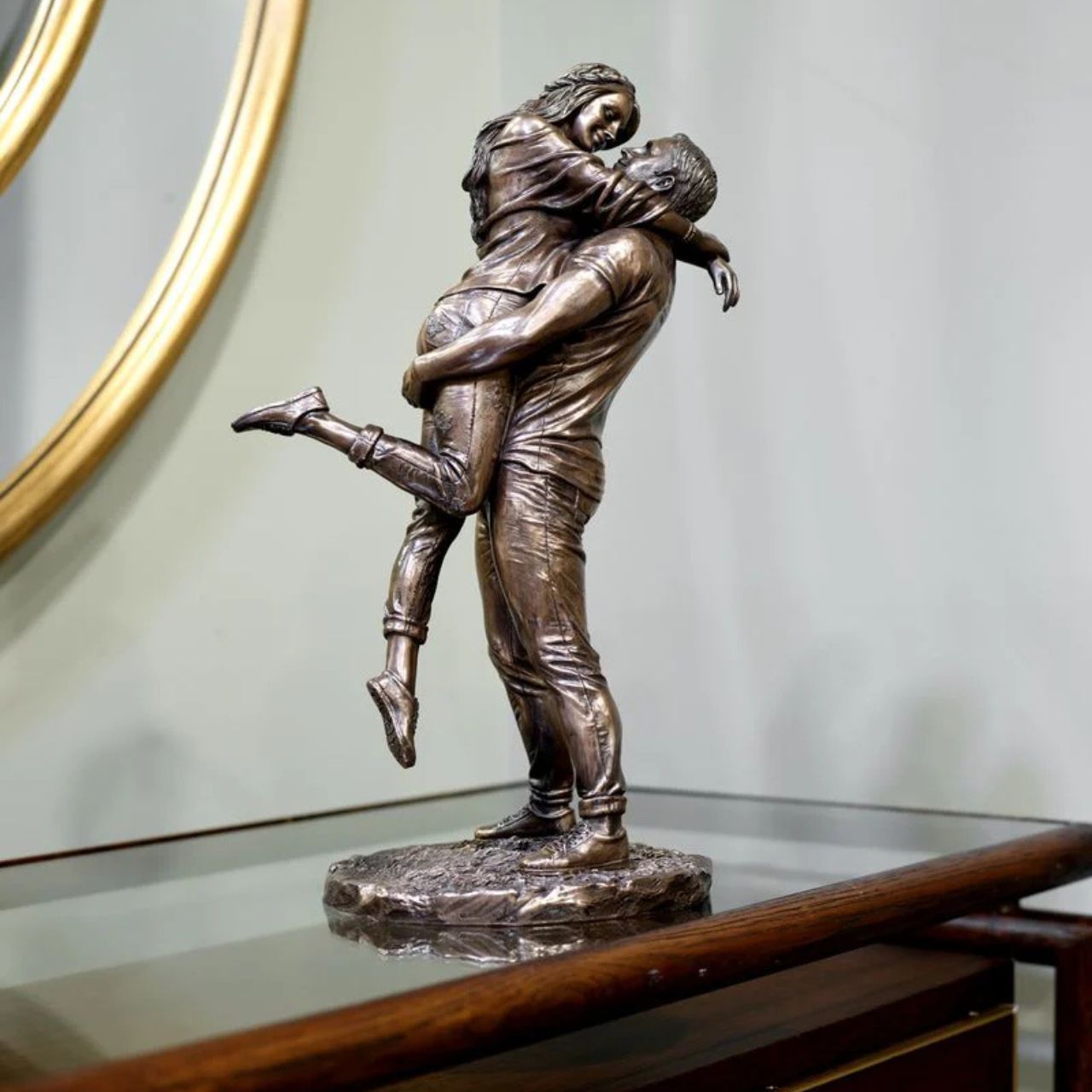 A beautiful bronze coloured statue of a couple in a loving embrace.