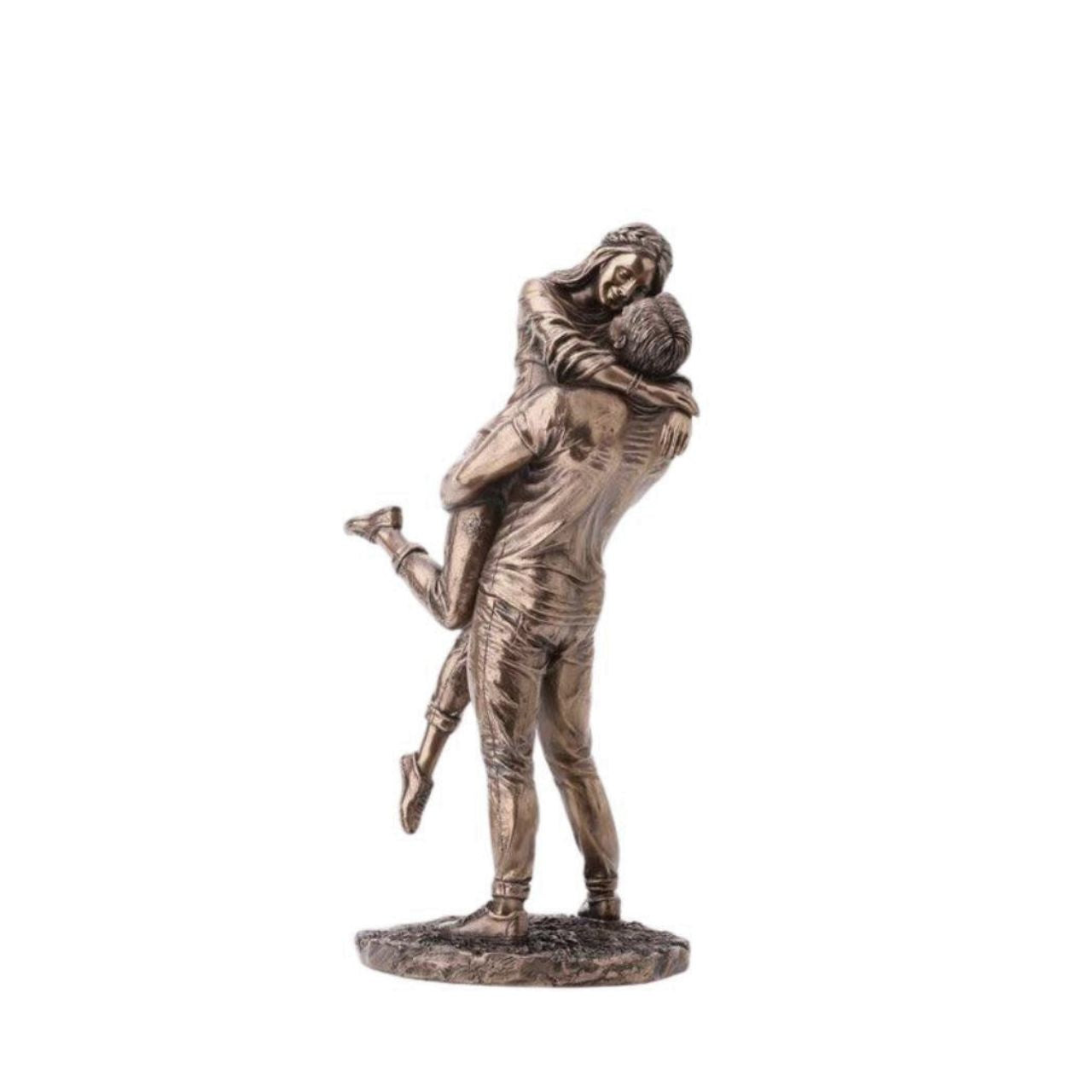 A beautiful bronze coloured statue of a couple in a loving embrace.