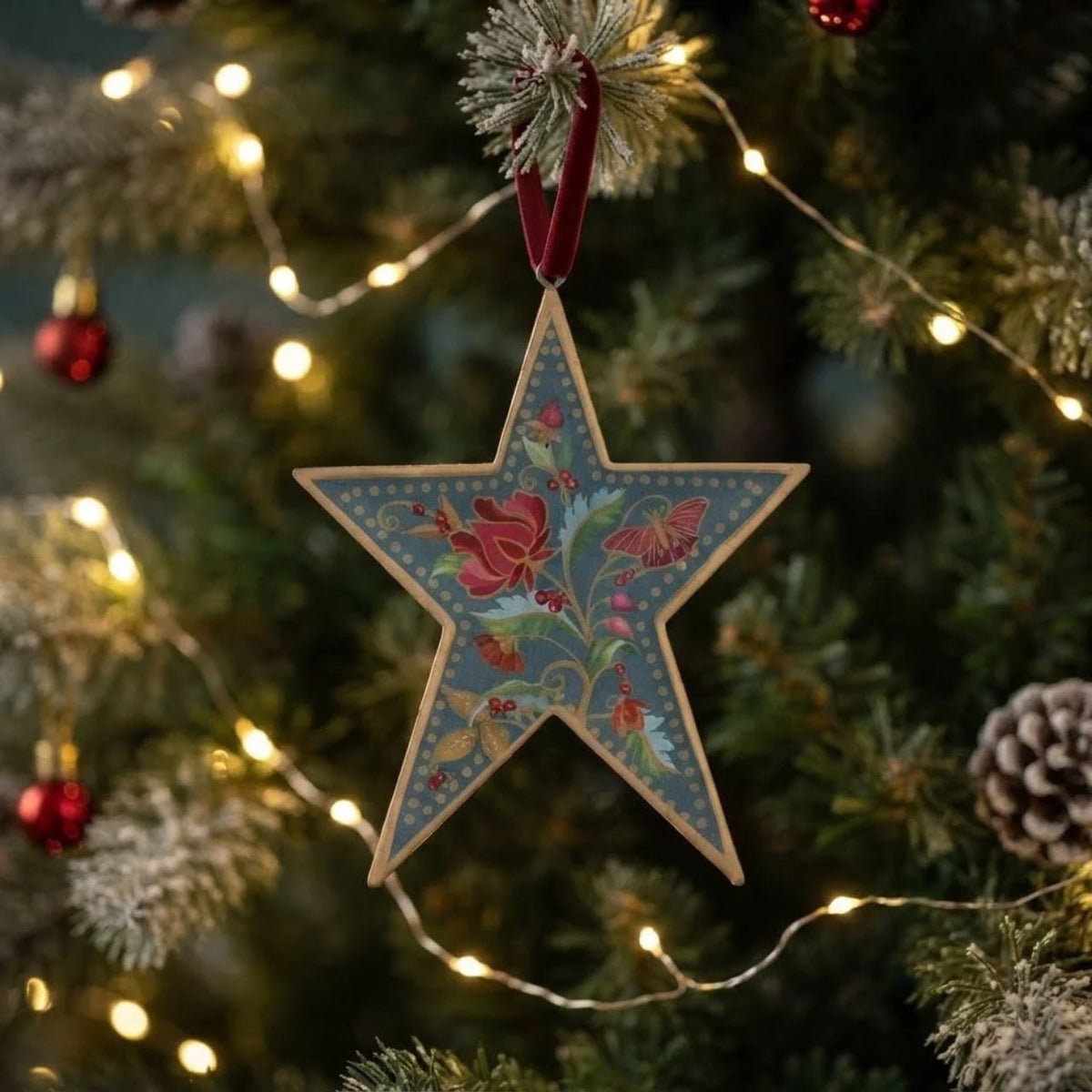 Bring festive charm to your tree with this exquisite Gisela Graham Blue Floribunda Heart &amp; Star Hanging Ornament. Crafted from 100% tin, this delicate piece features intricate blue floribunda detailing in a charming dual design—choose between a heart or star shape to suit your décor style.