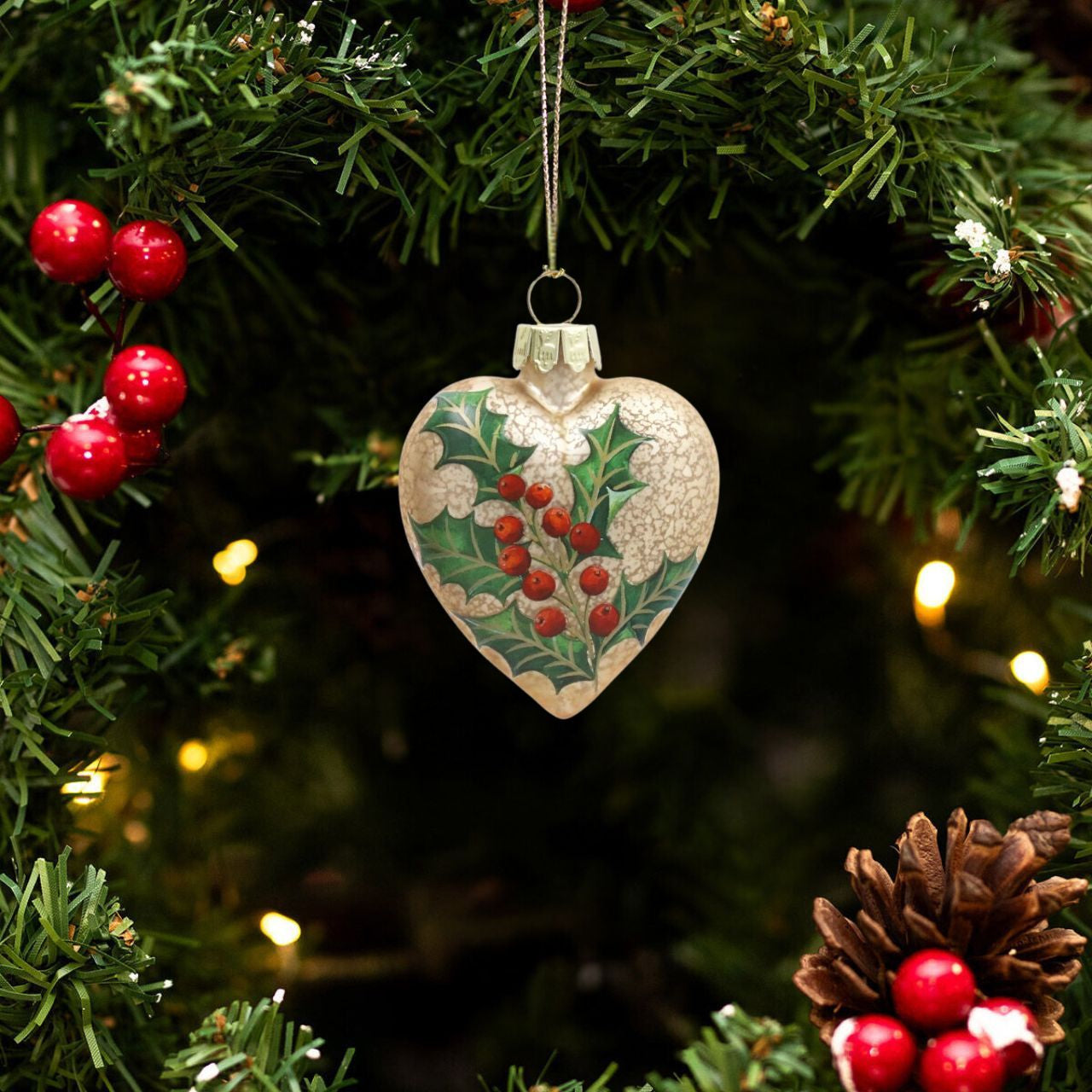 Elevate your holiday décor with the Gisela Graham Antique Gold Heart Bauble. Featuring a refined matte finish adorned with delicate holly details, this elegant glass ornament brings a timeless charm to your Christmas tree.
