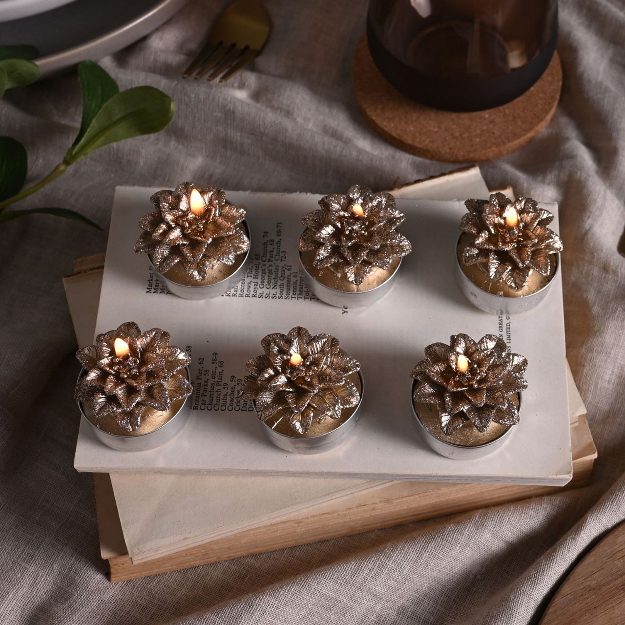 Gold Christmas Poinsettia Tealights Set of 6  A set of 6 gold poinsettia tea lights from THE SEASONAL GIFT CO.  These glittering tea lights are an adorable addition to homes during the festive season.