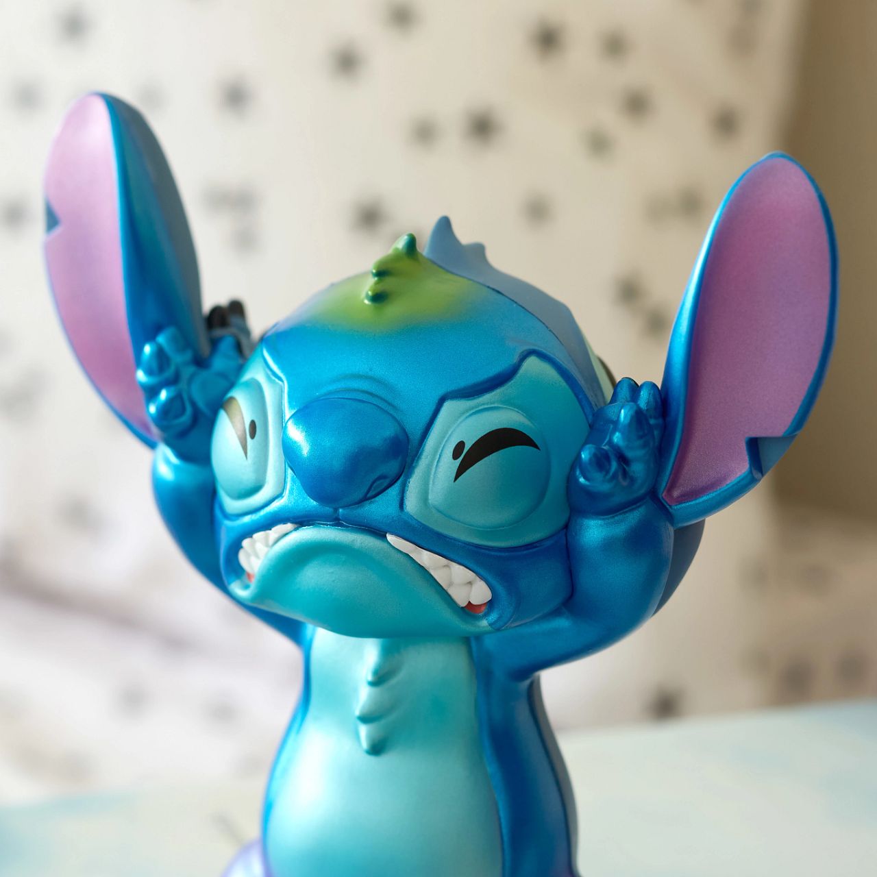 See both sides of Stitch with this double faced figurine. Featuring his happy, mischievous side in his trademark blue, and then on the other, a more pearlescent version of Stitch with a sad face.