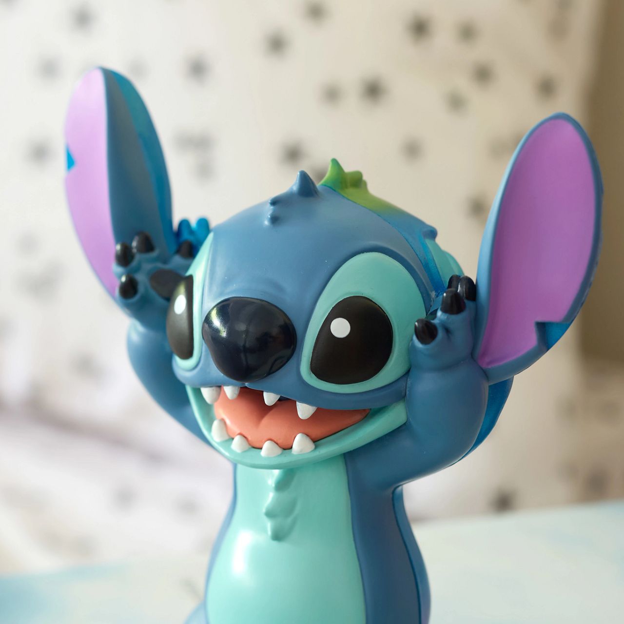 See both sides of Stitch with this double faced figurine. Featuring his happy, mischievous side in his trademark blue, and then on the other, a more pearlescent version of Stitch with a sad face.