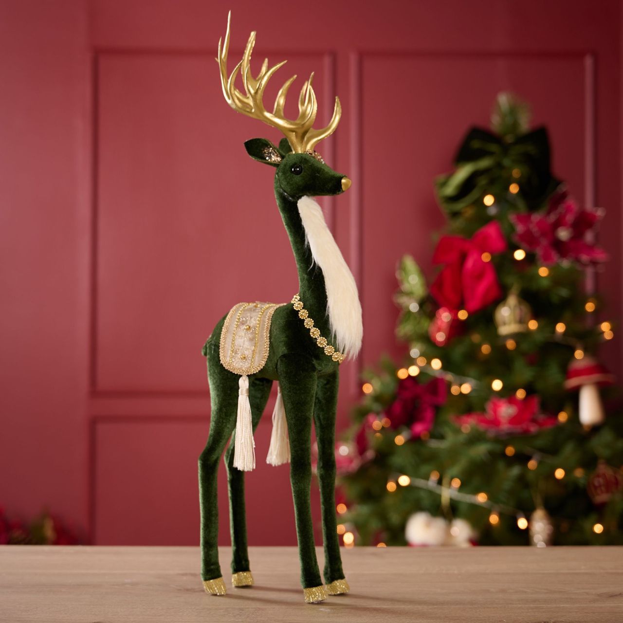 Green Velvet Standing Deer. Bring some festive cheer into the home this winter with this adorable cosy deer figurine. This green and white deer is dressed to impress. With gentle eyes and perky antlers, this peaceful deer will stand out as a beautiful item.