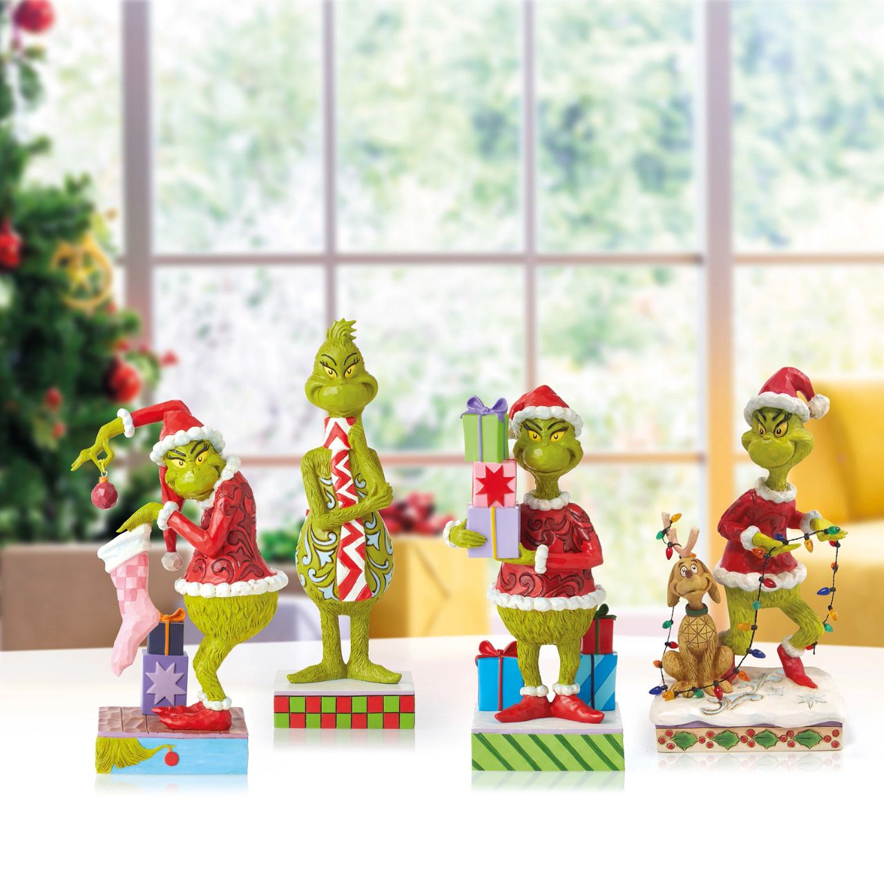 Grinch Holding Presents Figurine  Is the Grinch stealing presents again or has his heart changed to a kinder shape? You decide The Grinch's intentions when placing this colourful Jim Shore design in your home. Whatever his motive, The Grinch is giddy to be apart of your holiday.
