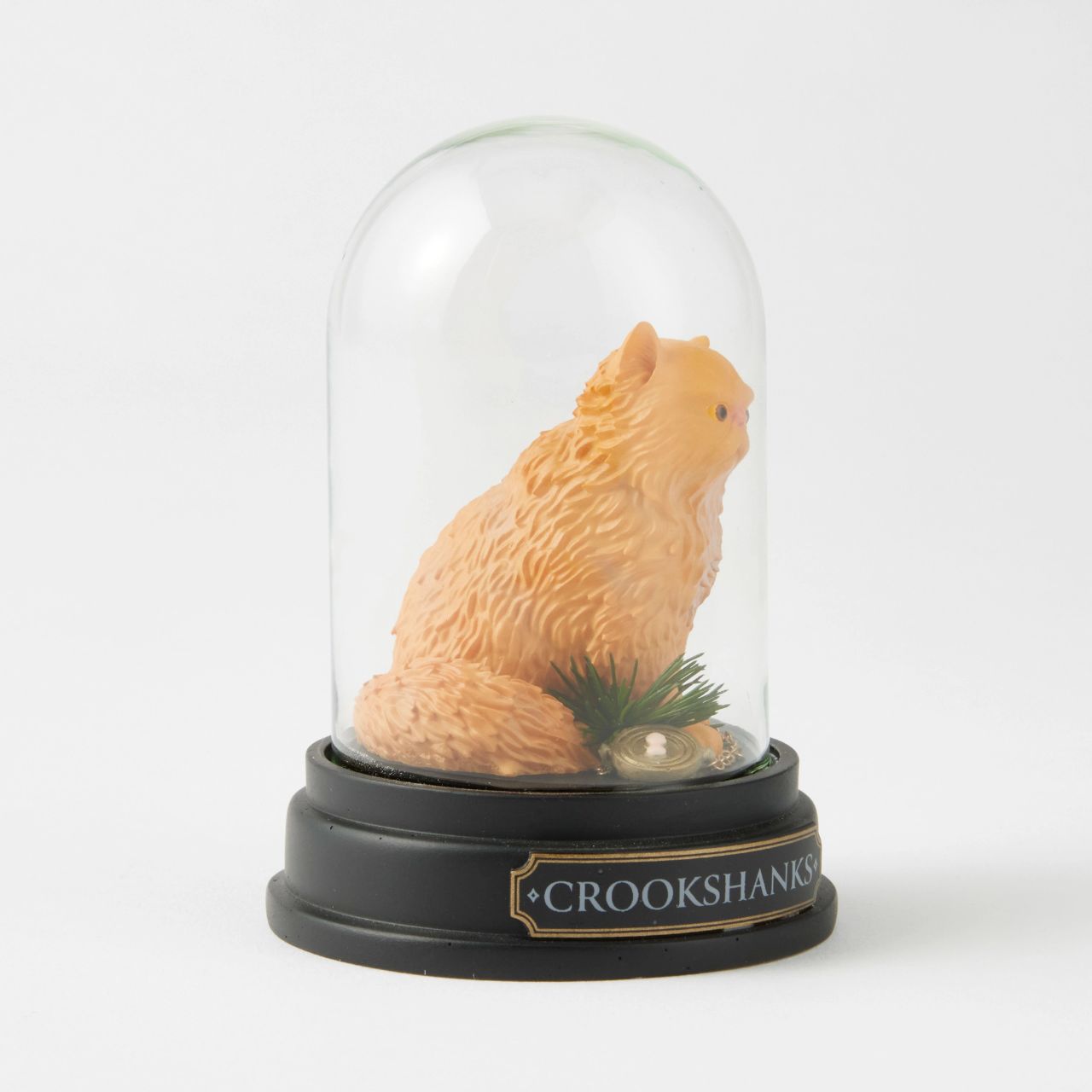 Capturing the essence of Hermione's beloved ginger-coloured feline friend, this intricately detailed sculpted and hand-painted miniature figure presented under a clear glass dome