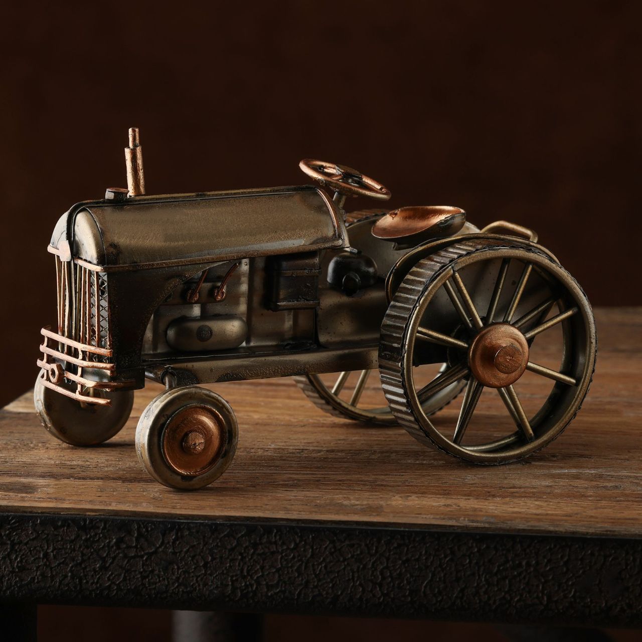 Introducing the Harvey Makin Ornament - Tractor, an embodiment of vintage charm with its intricate details and prominent engine. This model, with its large wheels, is a nostalgic nod to the heart of rural life, making it a perfect gift for those who appreciate classic machinery.