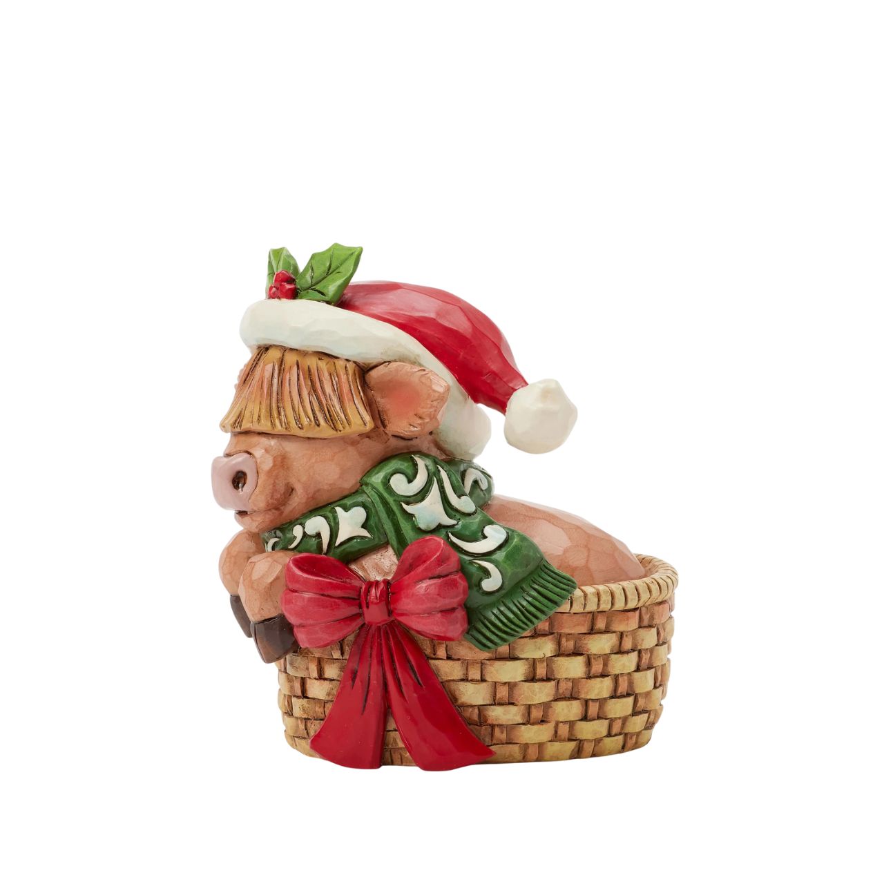 This adorable Jim Shore highland cow miniature radiates holiday cheer from within a cozy basket adorned with a festive bow. Dressed in a cheerful scarf and a Santa hat trimmed with holly, this delightful piece brings warmth and whimsy to your home.