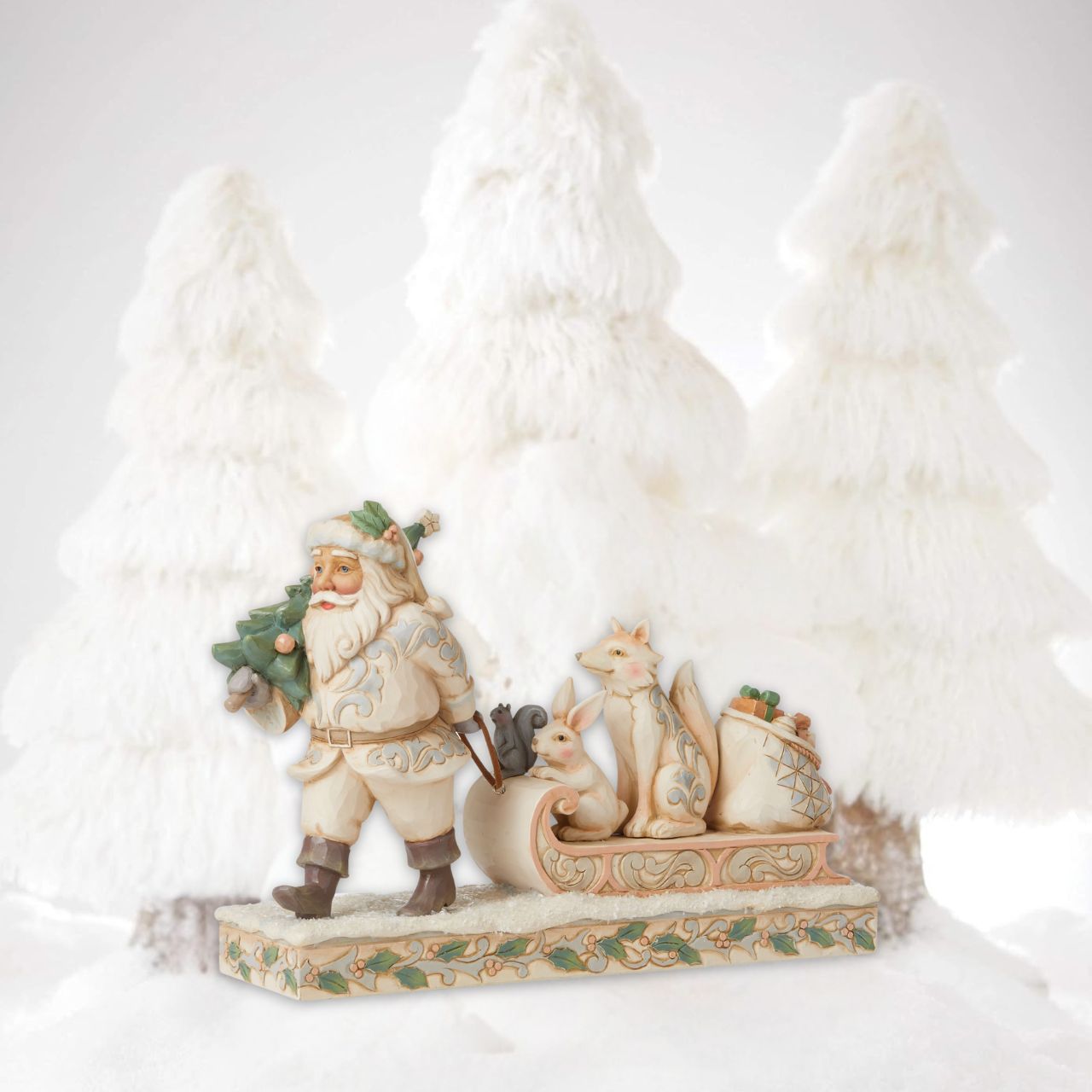 "A Wandering We Go" Santa is getting ready for Christmas with his furry friends. This piece features Santa dressed in the iconic, muted colours of White Woodland, whilst pulling a sled of forest animals and gifts. The base is decorated with a holly theme mixed with Jim Shore's traditional rosemailing.