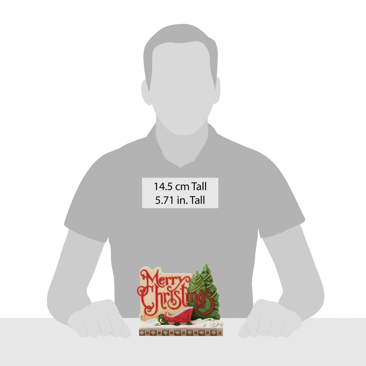 This festive Christmas at the Lodge Jim Shore holiday sign cheerfully reads "Merry Christmas" in curly, joyful script. Featuring decorated pine trees, a red and green sled on freshly fallen snow, this inviting piece brings holiday warmth and wishes every year.