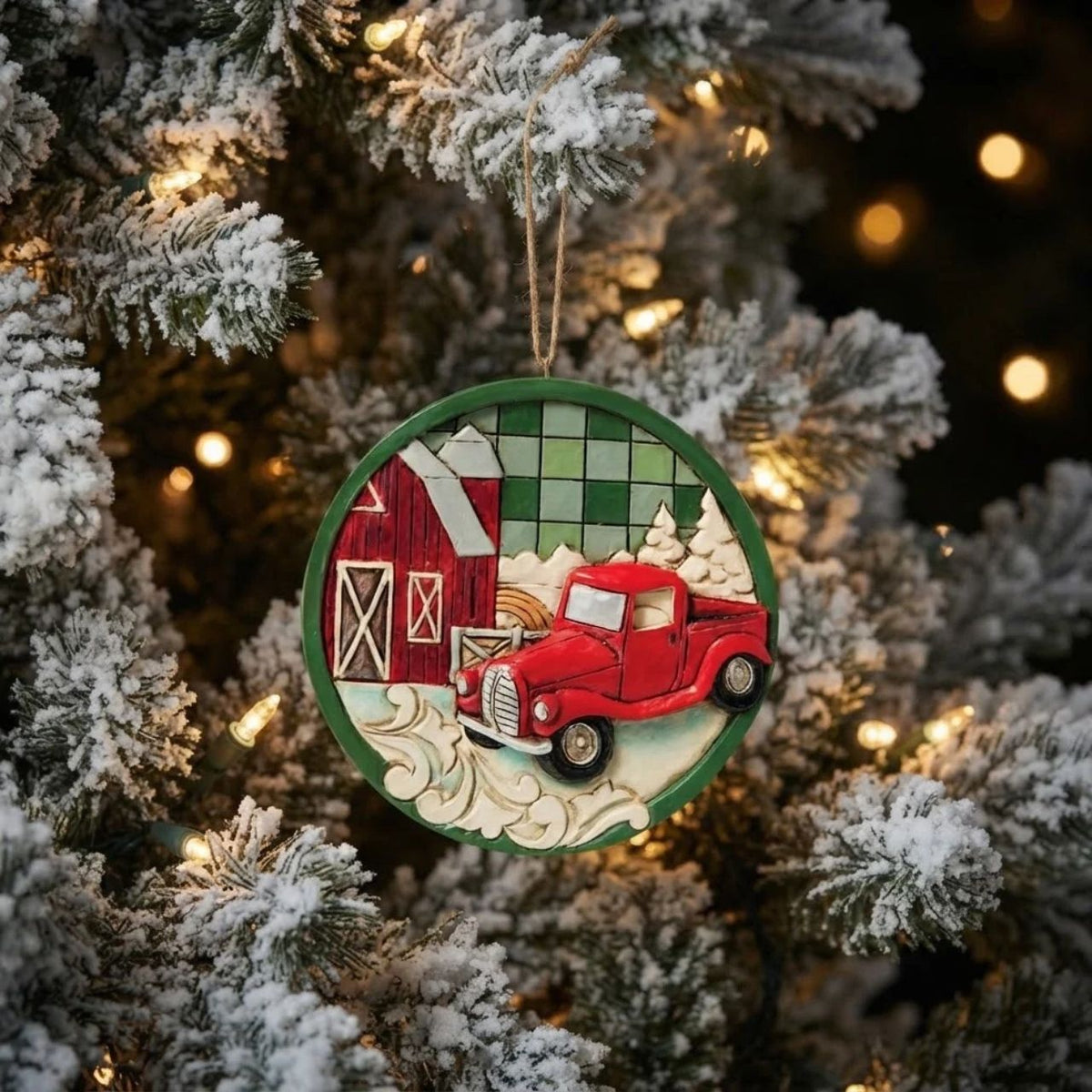 This charming Jim Shore Highland Glen ornament showcases a cozy farm scene with a classic red pickup truck surrounded by lush pines, all set against a green plaid background. This festive piece shares a calming sense of rural holiday charm.