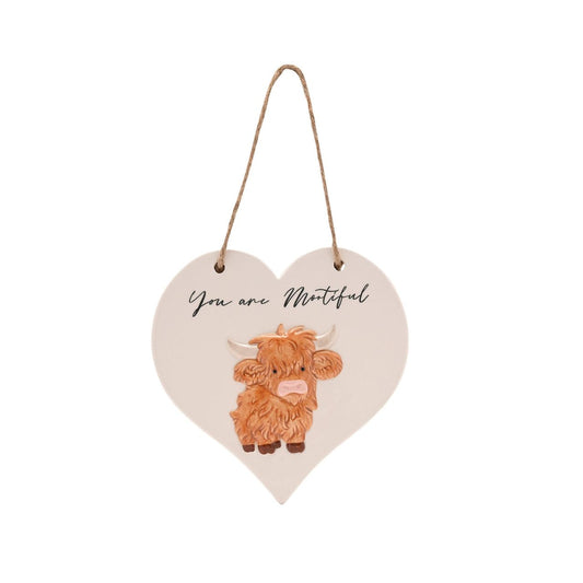 This charming ceramic plaque showcases a whimsical highland cow illustration and the playful message “You are Mootiful”. Shaped like a heart and finished with a rustic rope hanger, it’s cosy design make it a lovely addition to any home.