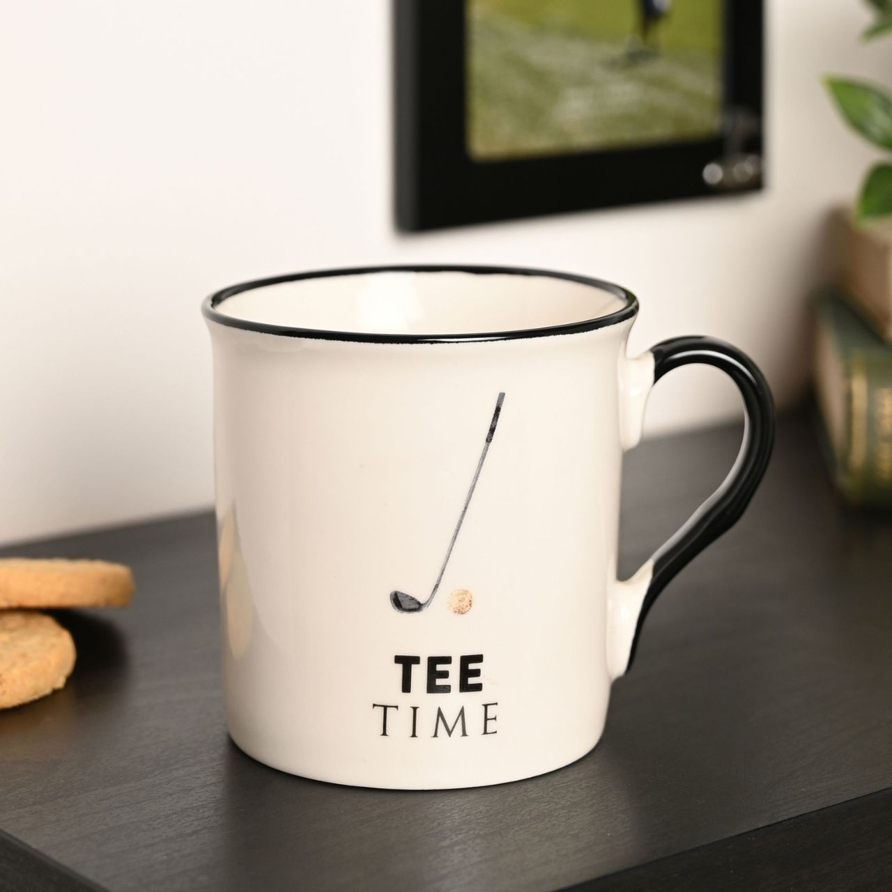 A white ceramic mug with the text "Tee Time" and a golf club icon printed on it.