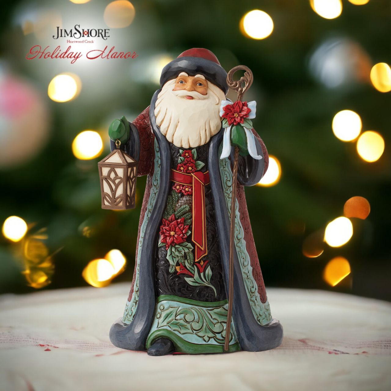 Heartwood Creek Holiday Manor Santa with Cane Figurine  Designed by award winning artist Jim Shore as part of the Heartwood Creek Holiday Manor Collection, hand crafted using high quality cast stone and hand painted, this Santa with his cane is perfect for the Christmas season. Packaging, Full colour, fully branded gift box with photo.