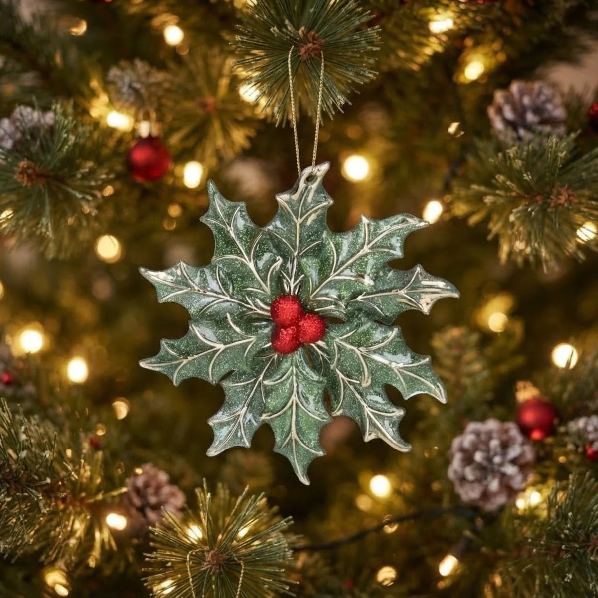 A festive addition to any holiday display, this Gisela Graham hanging ornament combines delicate holly leaf details with an elegant snowflake design.