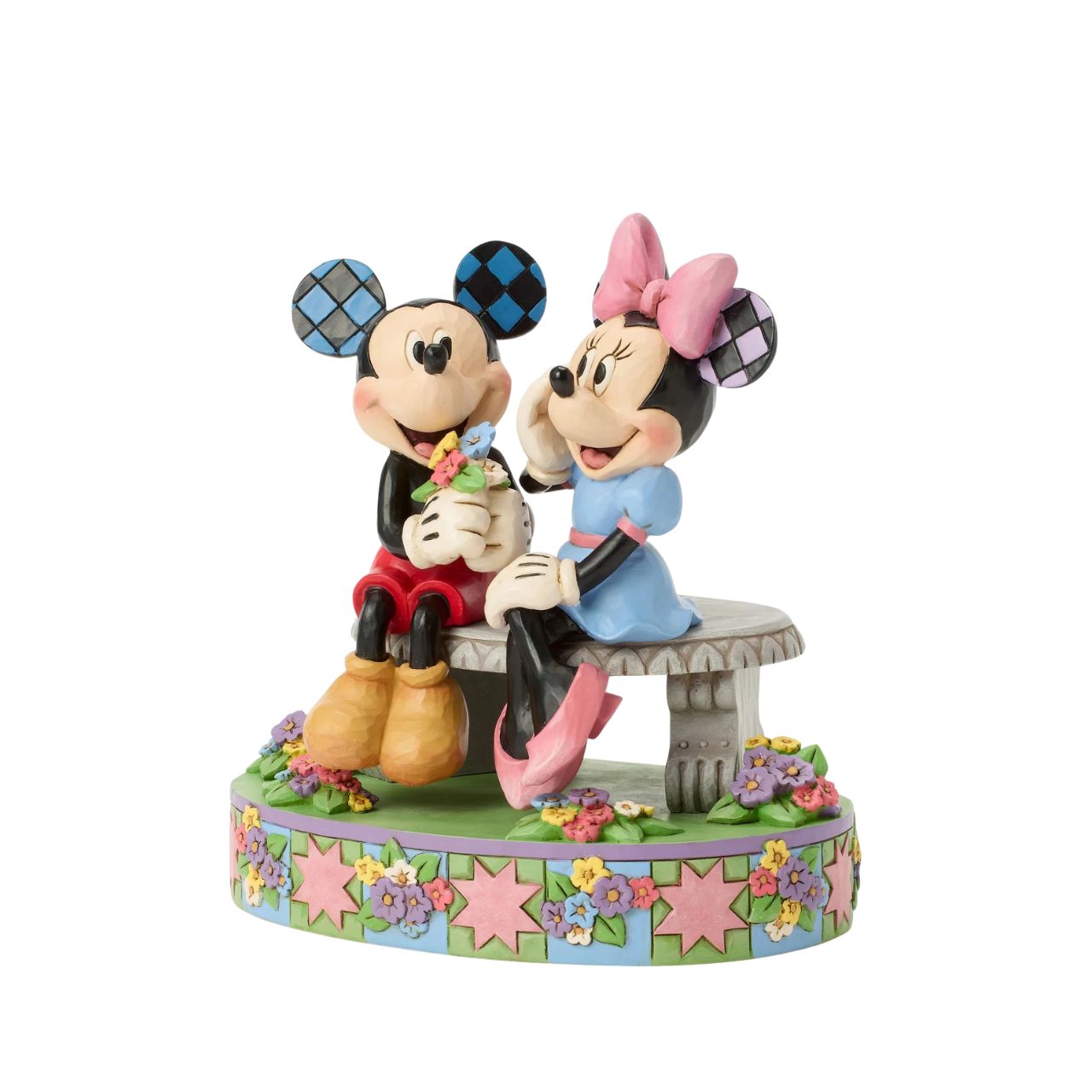 Mickey and Minnie share a sweet moment on a park bench in this romantic Jim Shore scene. Surrounded by colourful flowers and Jim's rosemaling and quilt patterns, Mickey presents Minnie with a fresh bouquet as she blushes.