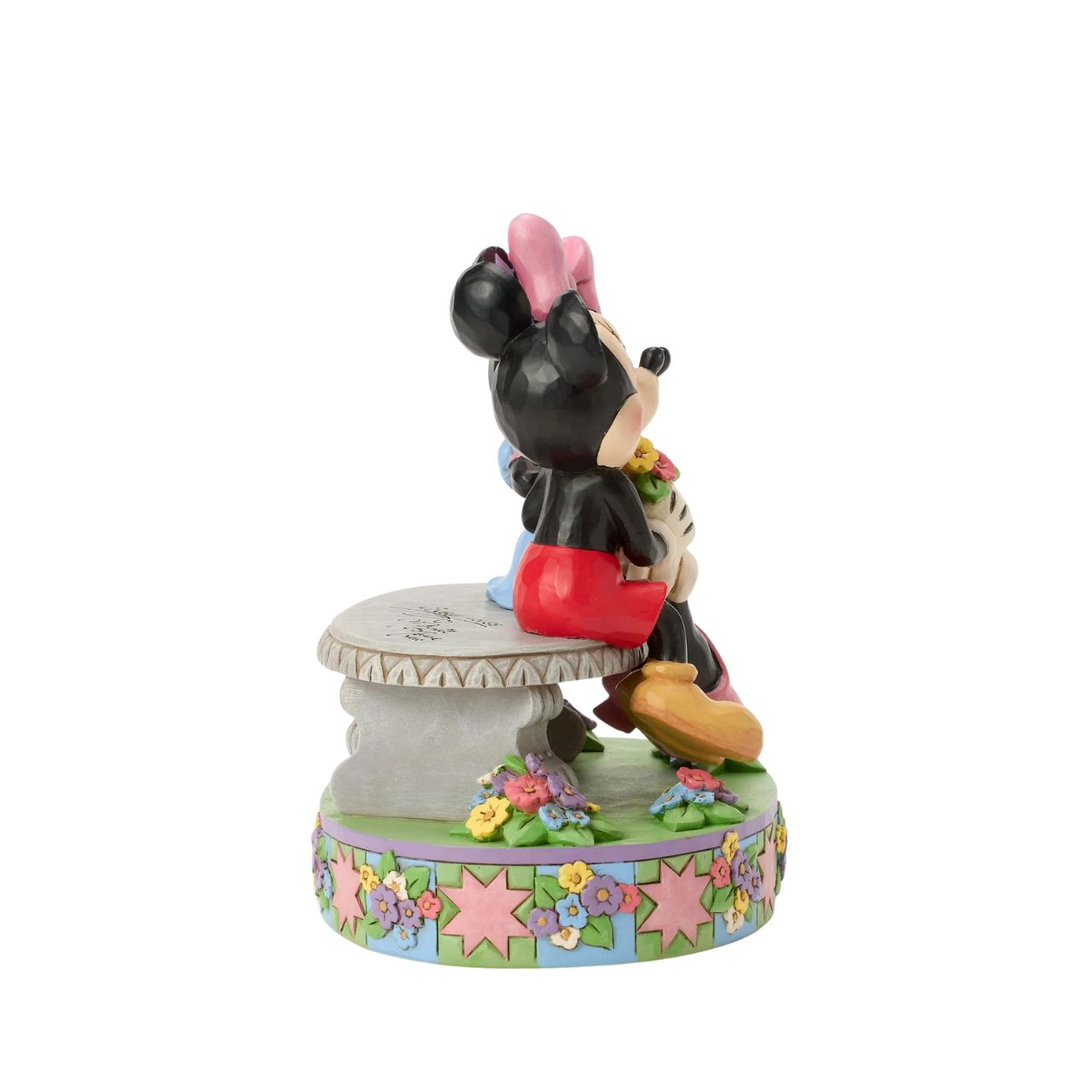 Mickey and Minnie share a sweet moment on a park bench in this romantic Jim Shore scene. Surrounded by colourful flowers and Jim's rosemaling and quilt patterns, Mickey presents Minnie with a fresh bouquet as she blushes.