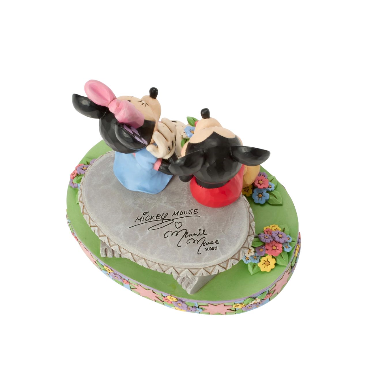 Mickey and Minnie share a sweet moment on a park bench in this romantic Jim Shore scene. Surrounded by colourful flowers and Jim's rosemaling and quilt patterns, Mickey presents Minnie with a fresh bouquet as she blushes.