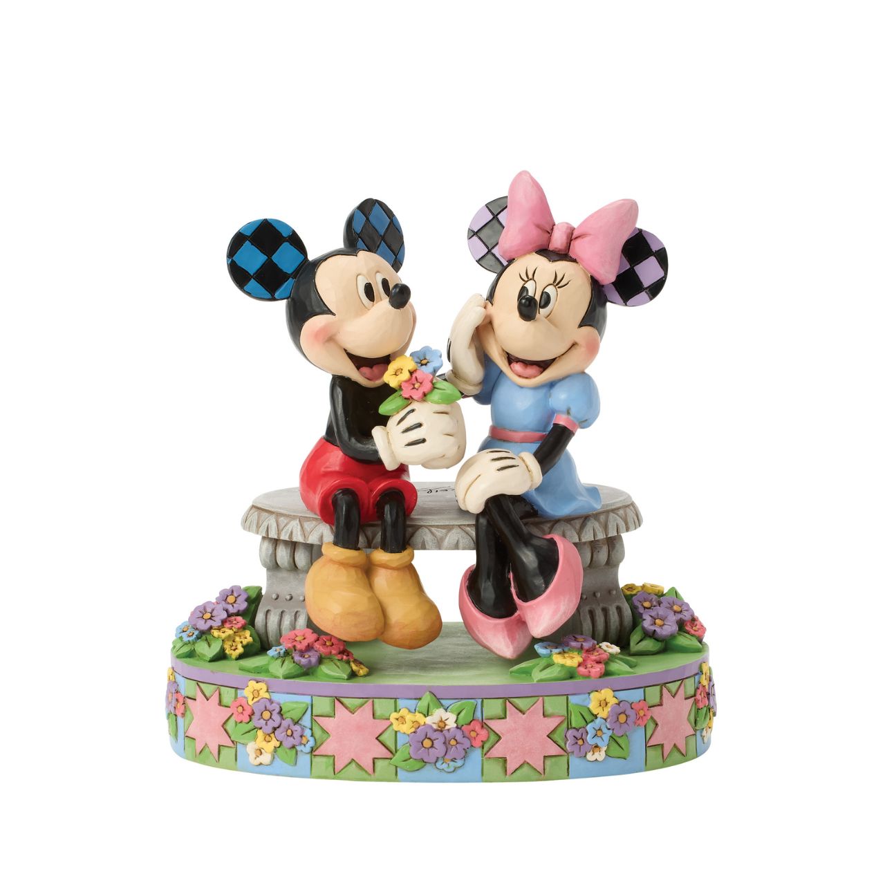 Mickey and Minnie share a sweet moment on a park bench in this romantic Jim Shore scene. Surrounded by colourful flowers and Jim's rosemaling and quilt patterns, Mickey presents Minnie with a fresh bouquet as she blushes.