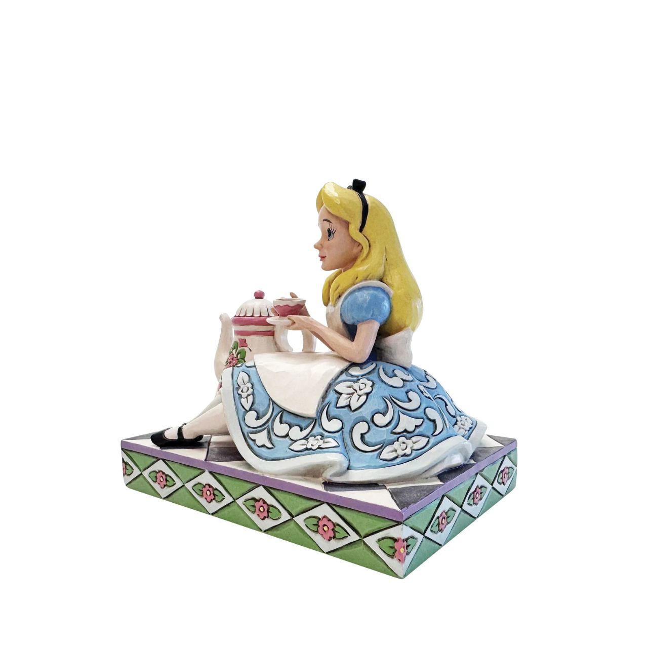 Alice sips beside a giant teapot in this whimsical Jim Shore creation. Inspired by Alice in Wonderland, this charming scene celebrates the imagination, playfulness, and magic of Disney's most curious tea party.