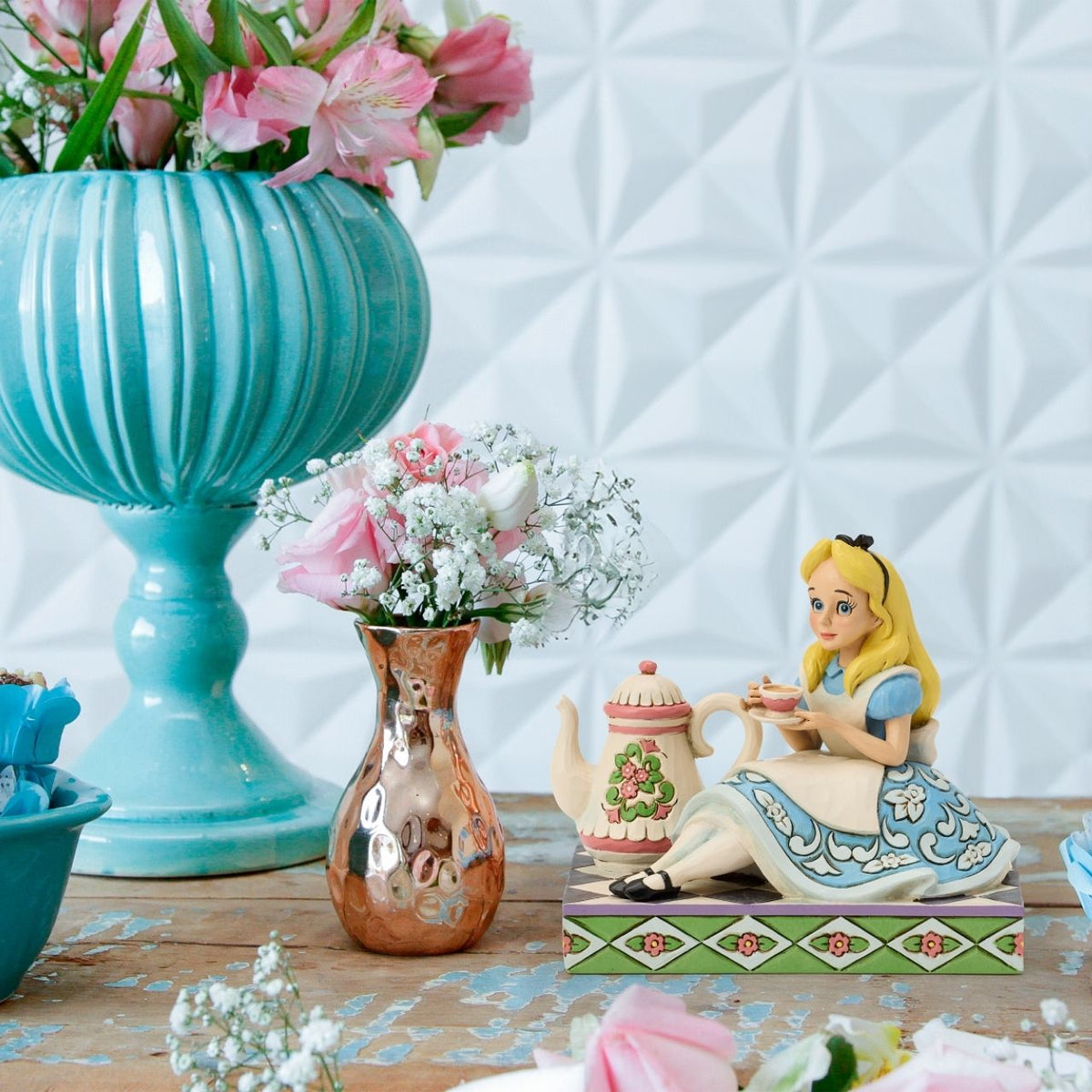 Alice sips beside a giant teapot in this whimsical Jim Shore creation. Inspired by Alice in Wonderland, this charming scene celebrates the imagination, playfulness, and magic of Disney's most curious tea party.