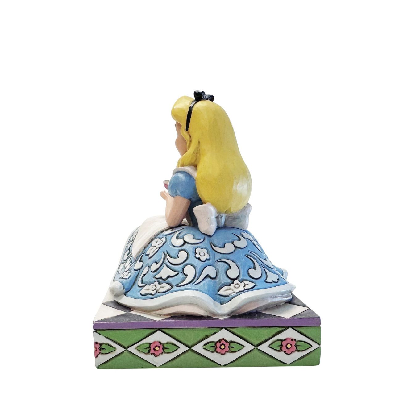 Alice sips beside a giant teapot in this whimsical Jim Shore creation. Inspired by Alice in Wonderland, this charming scene celebrates the imagination, playfulness, and magic of Disney's most curious tea party.